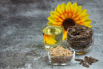 Sunflower, sunflower seeds and oil on a table